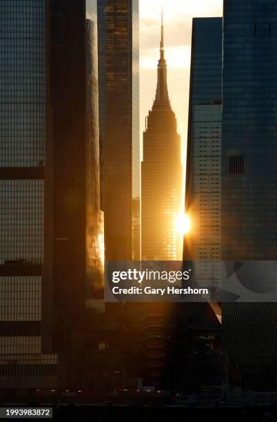 The sun rises behind the Empire State Building and Hudson Yards in New York City on February 7 as seen from Weehawken, New Jersey.