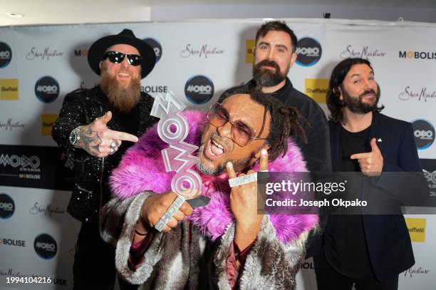 Arya Goggin, Daniel Pugsley, Benji Webbe and Michael Fry of Skindred pose with the Best Alternative Music Act award in the winners room during the...