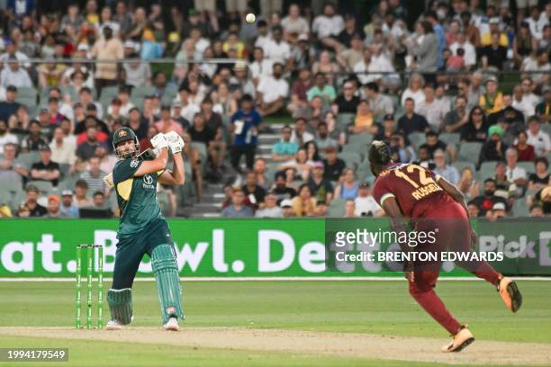 Australia's Tim David plays a shot off West Indies' Andre Russell during the second Twenty20 international cricket match between Australia and West...