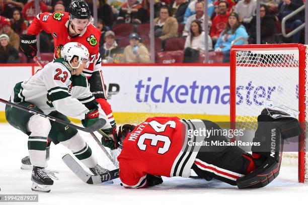 Petr Mrazek of the Chicago Blackhawks makes a save against Marco Rossi of the Minnesota Wild during the third period at the United Center on February...