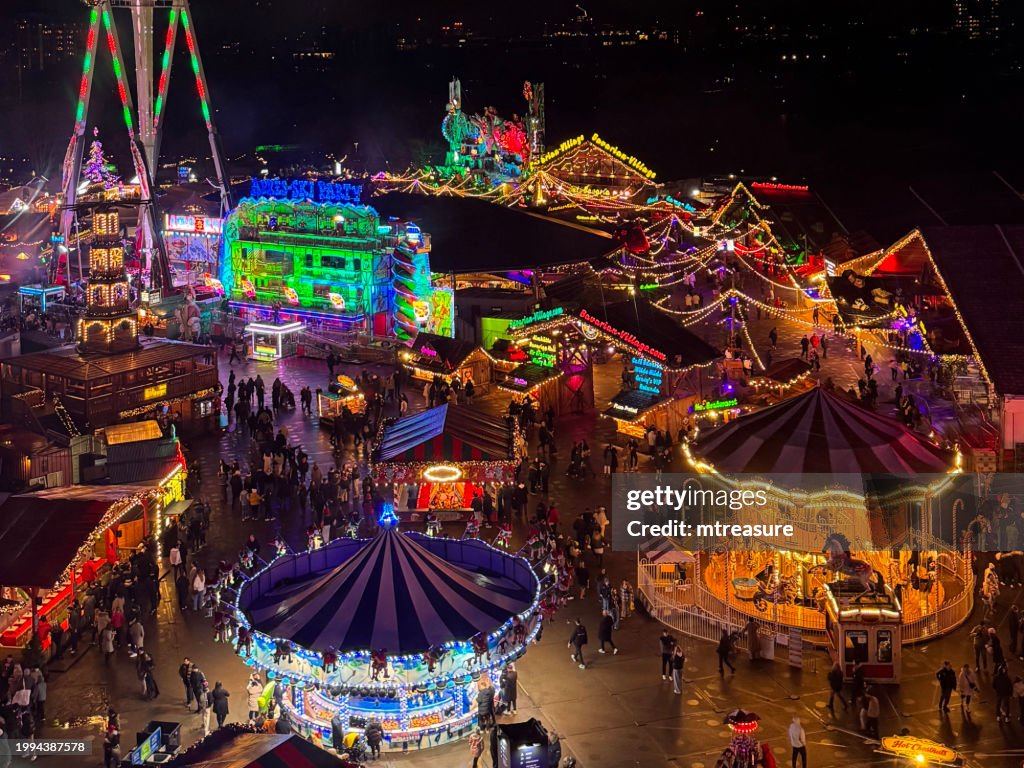 Close-up image of Ferris wheel point of view of Hyde Park Winter Wonderland, London, England, Christmas themed amusement park illuminated at night, aerial view, focus on foreground