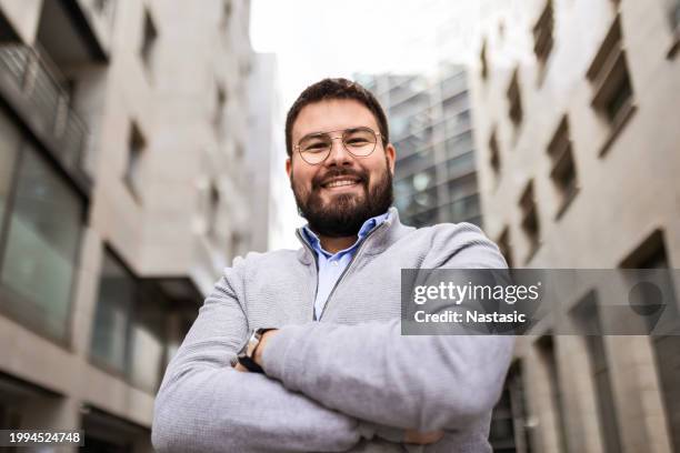 junger geschäftsmann vor urbaner kulisse - kräftig gebaut stock-fotos und bilder
