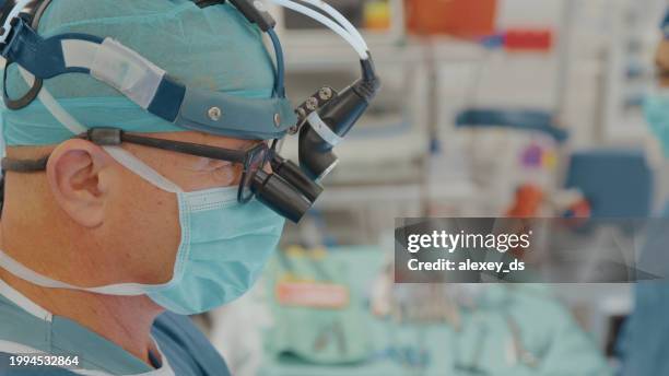 close-up of a doctor in the operating room wearing surgical gear - surgical loupes stock pictures, royalty-free photos & images