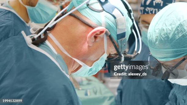 erfahrenes ärzteteam führt herzklappenoperation durch - herzoperation stock-fotos und bilder