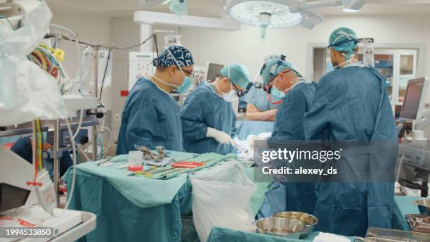 group of surgeons began heart surgery - open heart surgery stock pictures, royalty-free photos & images