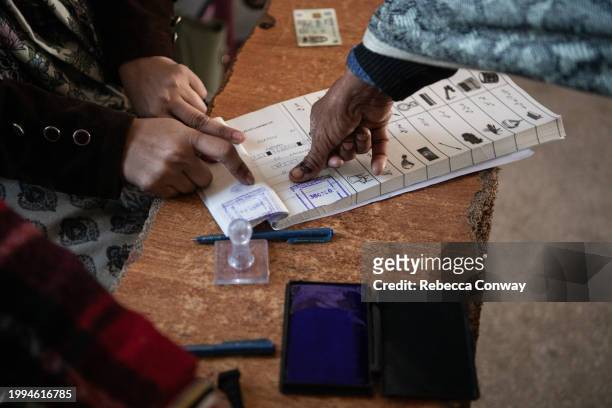 Pakistani voter collects ballot papers during polling for Pakistan's general election at a polling station on February 08, 2024 in Wahgrian,...