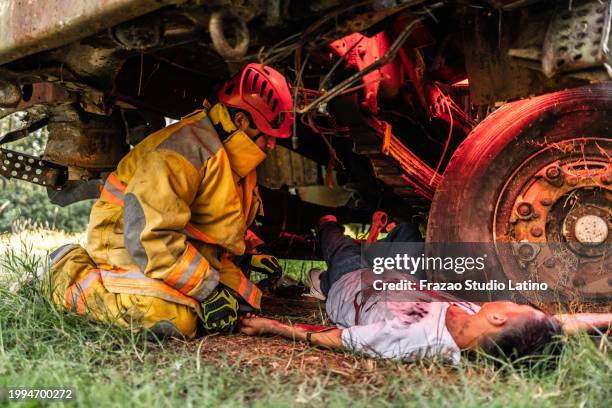 firefighters helping a car accident victim - accident victim stock pictures, royalty-free photos & images