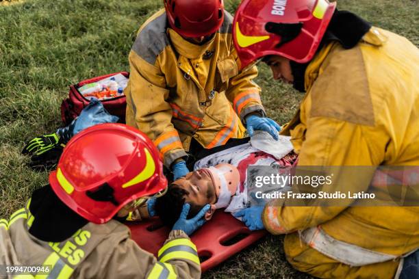 paramedics helping an accident victim - unconscious kid stock pictures, royalty-free photos & images