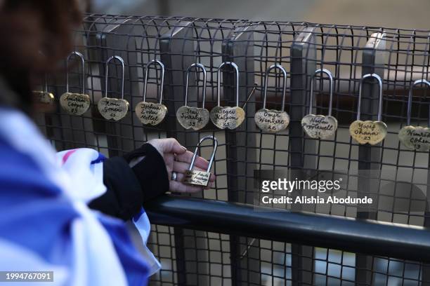 Woman holds a lovelock attached to the Lovelock Hostage Bridge on February 11, 2024 in London, England. The Lovelock Hostage Bridge has been created...