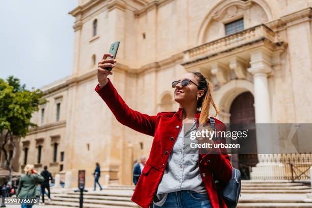 young businesswoman taking selfies on the street in valletta - malta business stock pictures, royalty-free photos & images