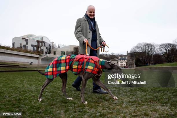 Scottish Green MSP Mark Ruskell poses with former racing greyhound, seven year old Bluesy, outside the Scottish Parliament on February 08, 2024 in...