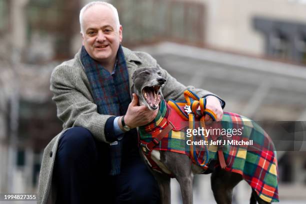 Scottish Green MSP Mark Ruskell poses with former racing greyhound, seven year old Bluesy, outside the Scottish Parliament on February 08, 2024 in...