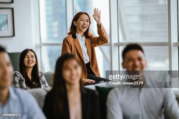 inquisitive engagement: young asian businesswomen participate in seminar presentation - colleague engagement stock pictures, royalty-free photos & images