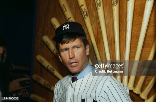 American baseball player Tommy John, a pitcher with the New York Yankees, posing in front of a display of baseball bats in New York, November 22nd...