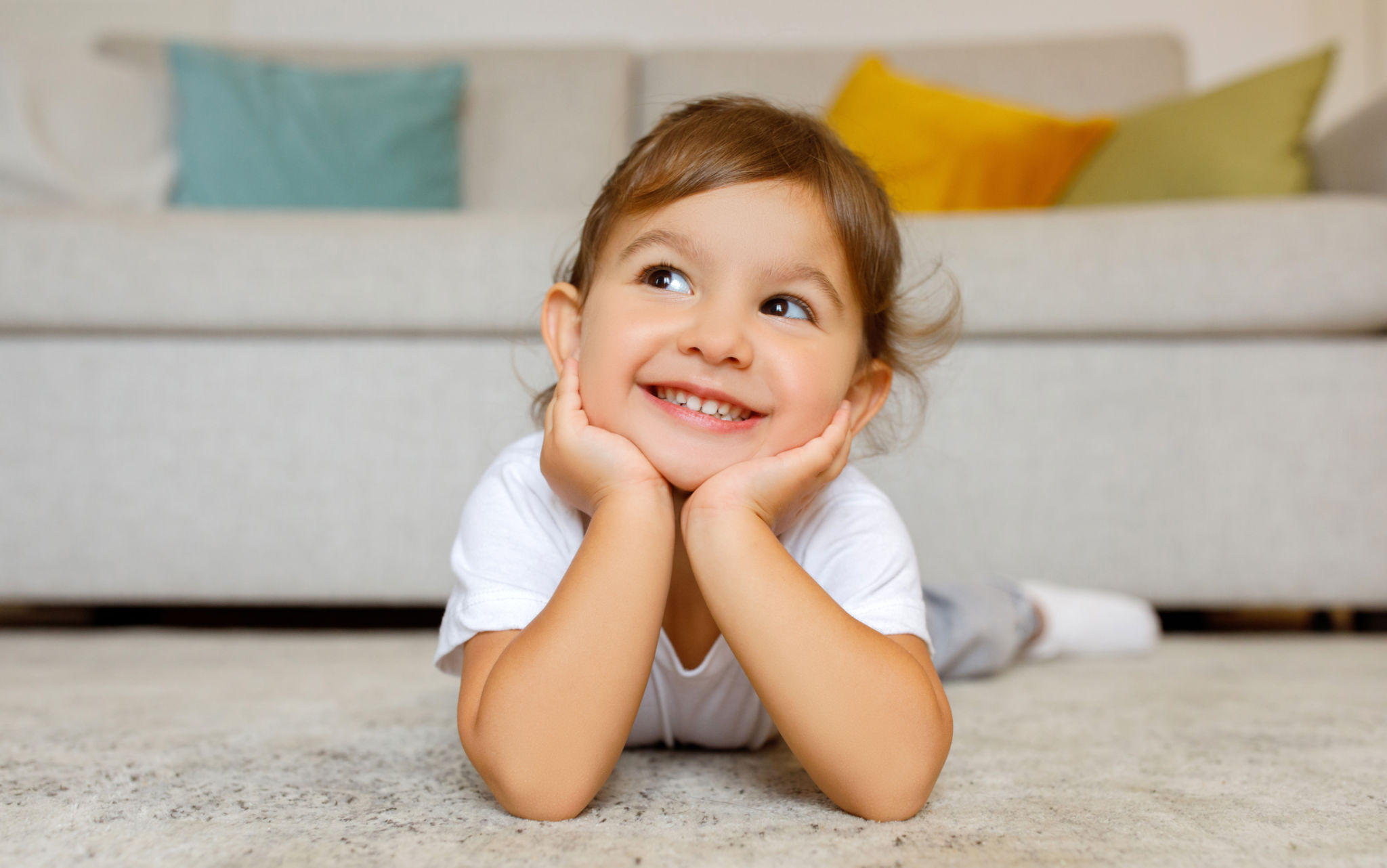Bambina carina allegra che sogna ad occhi aperti sul pavimento di casa Bambina carina allegra che sogna ad occhi aperti sul pavimento di casa