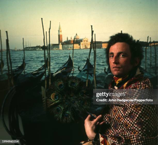 Irish born British artist and painter Patrick Procktor posed in front of a Venetian backdrop in London in 1970.