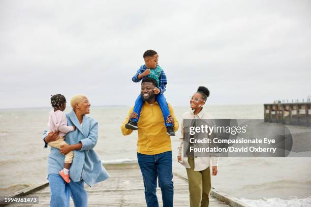 happy family enjoying walk by sea - route 13 stock pictures, royalty-free photos & images