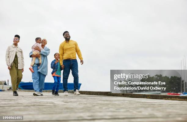 wide shot of family walking on beach boardwalk - route 13 stock pictures, royalty-free photos & images