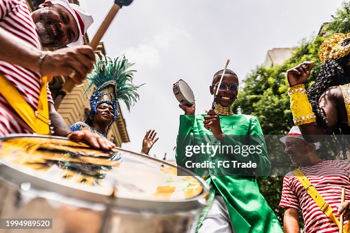Portrait of a young man playing tambourine at a street carnival party Portrait of a young man playing tambourine at a street carnival party