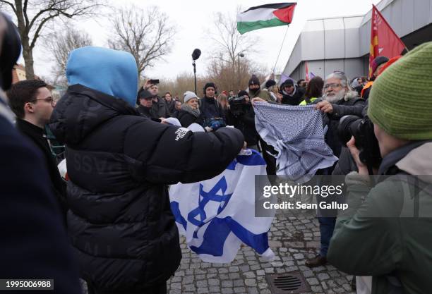 Pro-Israel activist waves an Israeli flag while taunting pro-Palestinian protesters at a pro-Palestinian demonstration at the Free University Berlin...