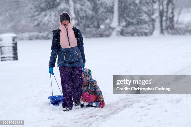 People walk through the snow in Pavilion Gardens on February 08, 2024 in Buxton United Kingdom. The Met Office issued two amber warnings for snow and...