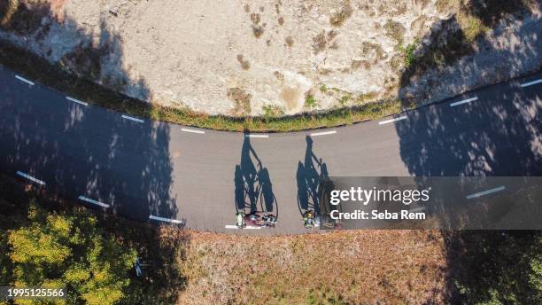 journey of two cyclists: shadows on the asphalt tell a tale - pirineos fotografías e imágenes de stock