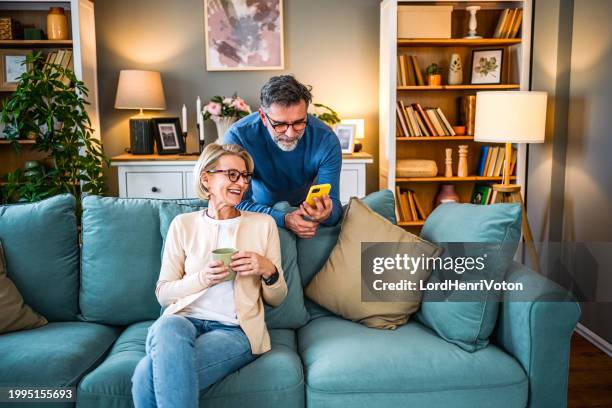 älteres paar mit handy - websurfen stock-fotos und bilder