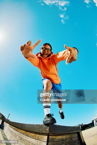 gen z teenager poses full body towards camera, showing attitude, shot wide angle against the sky. - fisheye stock pictures, royalty-free photos & images