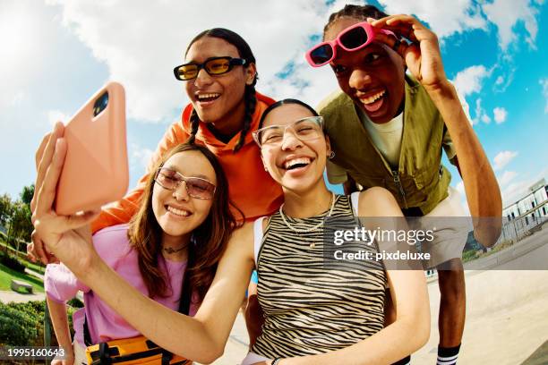 wide angle shot of gen z group of friends using a smartphone together. - city life authentic stock pictures, royalty-free photos & images