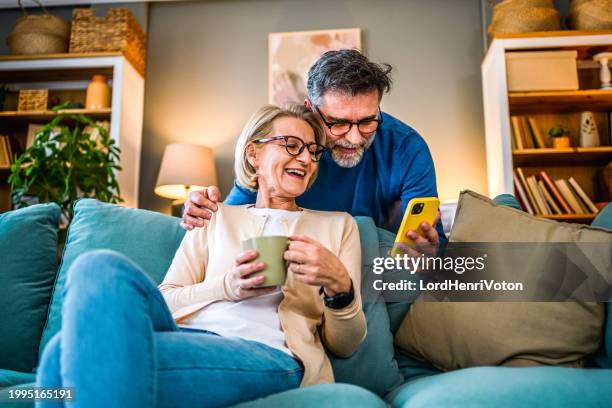 pareja mediante teléfono móvil - pareja madura fotografías e imágenes de stock