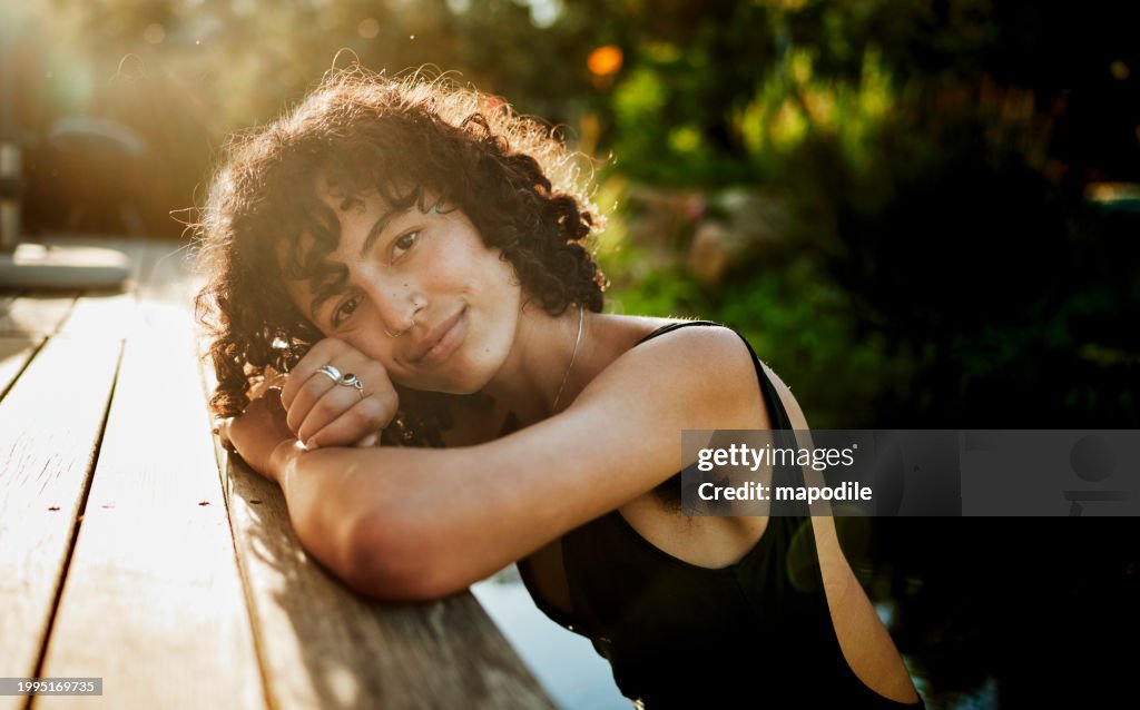 Mulher sorridente relaxando em uma piscina natural em um retiro de bem-estar
