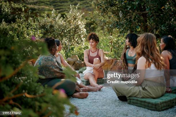 mujeres diversas hablando en círculo al aire libre en un retiro de bienestar escénico - reunión evento social fotografías e imágenes de stock