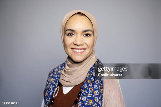 portrait of beautiful young islamic woman smiling on gray background - veil face stock pictures, royalty-free photos & images