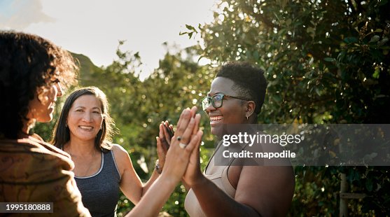 Mujeres sonriendo durante un ejercicio al aire libre en un pintoresco retiro de bienestar Mujeres sonriendo durante un ejercicio al aire libre en un pintoresco retiro de bienestar