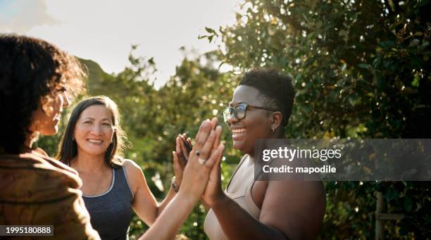 women smiling during an exercise outside at a scenic wellness retreat - people helping people stock pictures, royalty-free photos & images