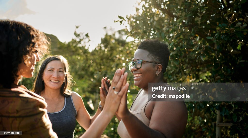 Mulheres sorrindo durante um exercício ao ar livre em um retiro panorâmico de bem-estar
