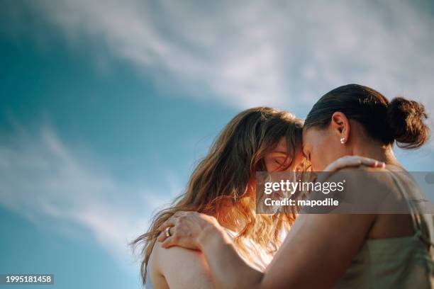 mujeres jóvenes de pie con los ojos cerrados y la frente juntas en un retiro de bienestar - amistad femenina fotografías e imágenes de stock