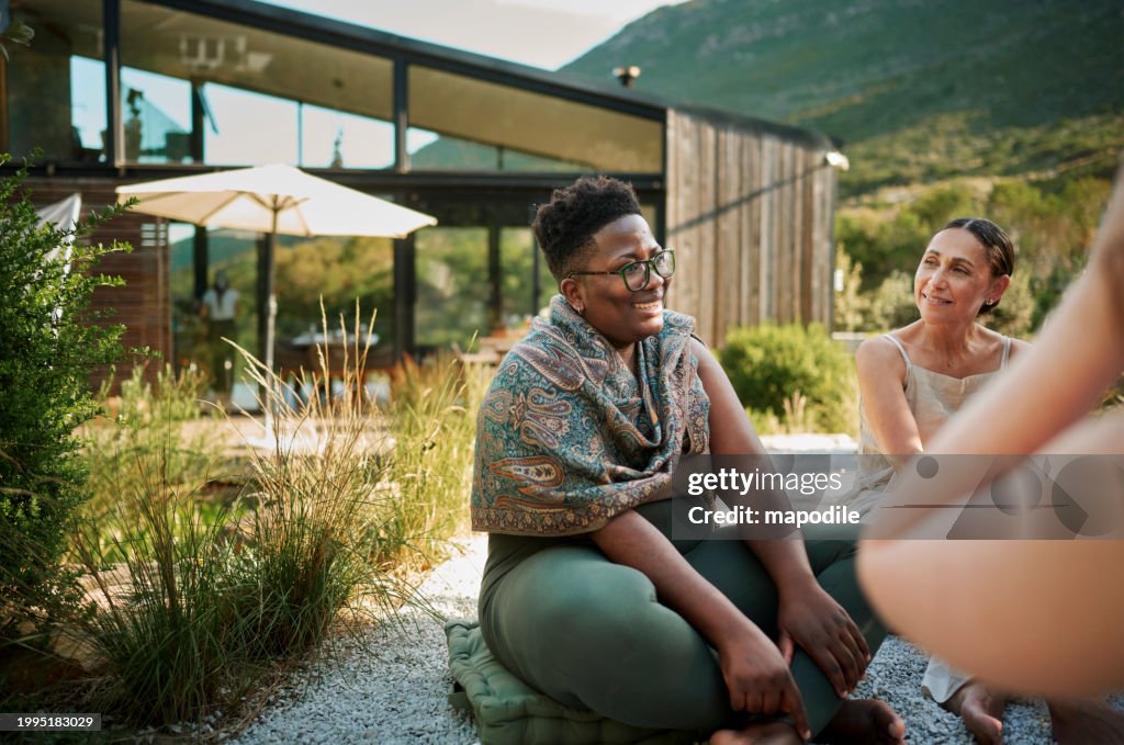 Smiling women talking in a circle during a session at a wellness retreat