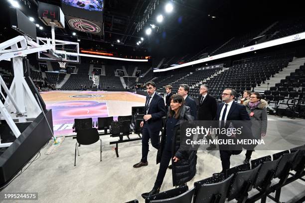 Paris' mayor Anne Hidalgo walks flanked by Deputy Director to the DG for the Olympic and Paralympic Games and Major Events Christophe Rosa and...