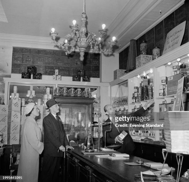 Retail clerk shows customers teas at Fortnum & Mason department store, Piccadilly, London, July 8th 1957.
