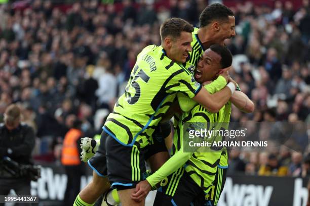 Arsenal's Brazilian defender Gabriel Magalhaes celebrates with teammates after scoring their third goal during the English Premier League football...