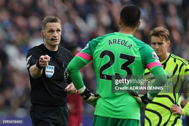English referee Craig Pawson indicates a penalty after the VAR clears a potential offside during the English Premier League football match between...