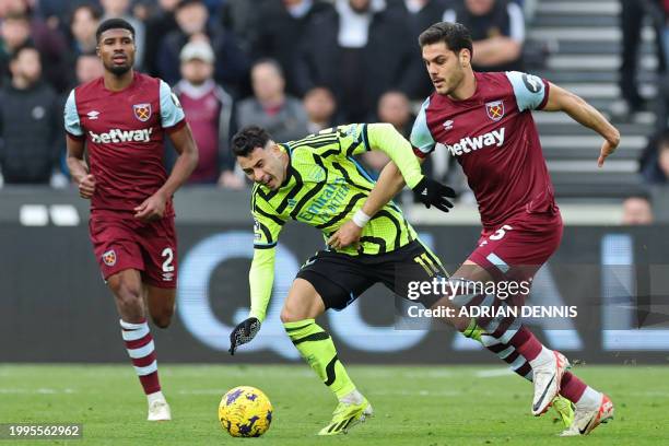 Arsenal's Brazilian midfielder Gabriel Martinelli vies with West Ham United's Greek defender Konstantinos Mavropanos during the English Premier...