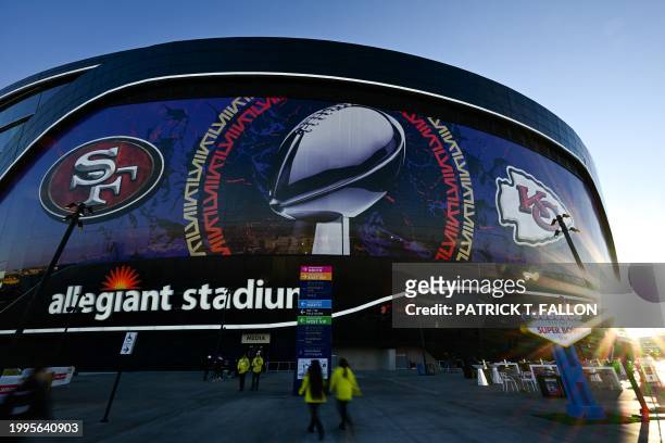 Allegiant Stadium stands at sunrise wrapped with the logos of the San Francisco 49ers and Kansas City Chiefs with the NFL Lombardi Trophy ahead of...