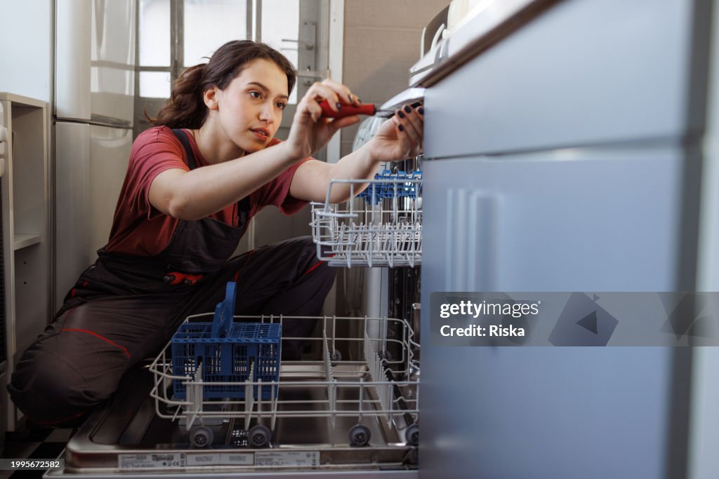 A repairwoman installing the dishwasher