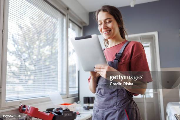 lifestyle and technology - a handywoman communicating with clients via digital tablet - building contractor computer stock pictures, royalty-free photos & images