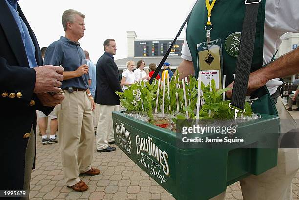 Tom Brisgone buys a Mint Julep from Rudi Keller prior to the 129th Kentucky Oaks on May 2, 2003 at Churchill Downs in Louisville, Kentucky.
