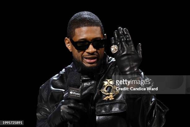 Usher holds up his "Coming Home" Super Bowl ring during the Super Bowl LVIII Pregame & Apple Music Super Bowl LVIII Halftime Show press conference at...