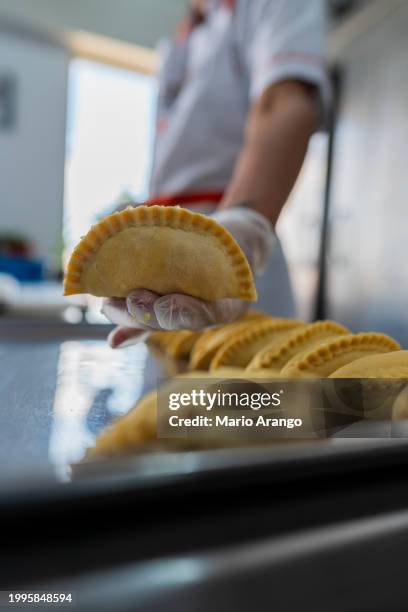 latino-angestellte befinden sich in der küche eines kleinen empanada-lebensmittelgeschäfts - kolumbianische kultur stock-fotos und bilder