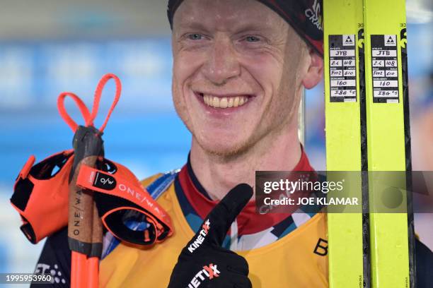 Norway's Johannes Thingnes Boe points at his skis as he celebrates winning the men's 12,5 km pursuit event of the IBU Biathlon World Championships in...